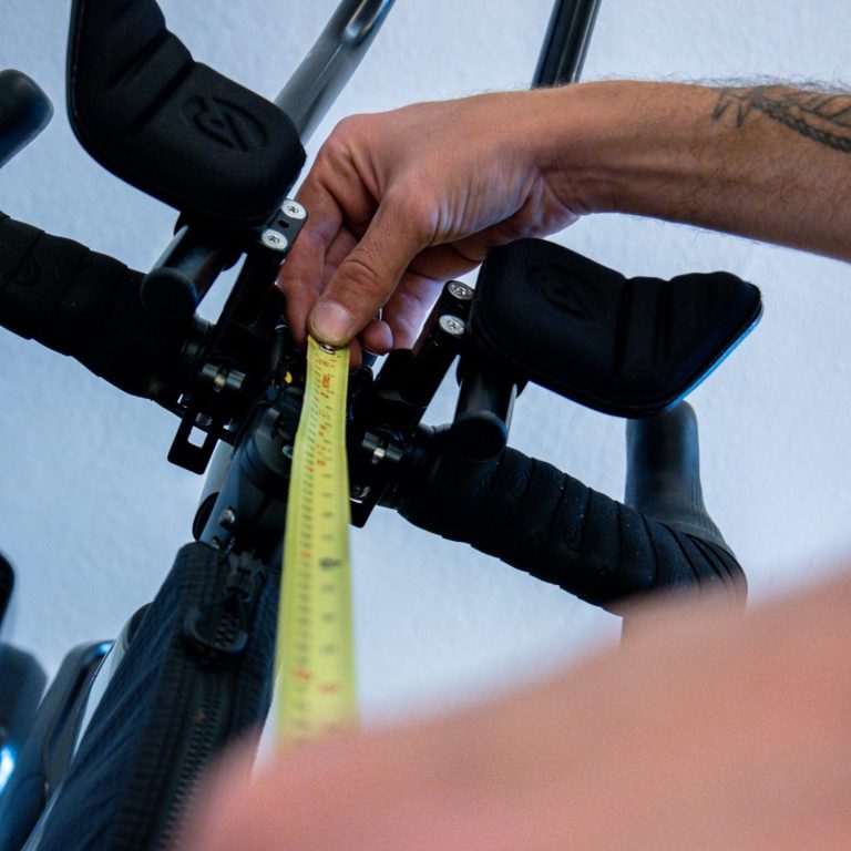 Radvermessung: Präzise Einstellung des Fahrrads Fahrradvermessung: Hand misst die Position zwischen Sattel und Lenker